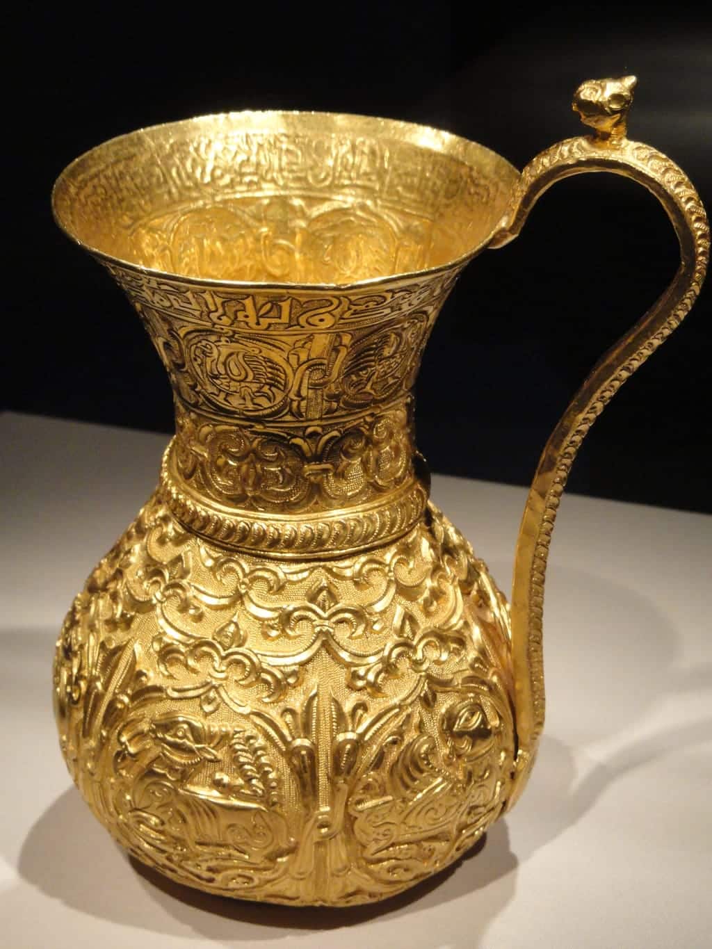 Vaso dourado com relevos ornamentados, fotografado de perto