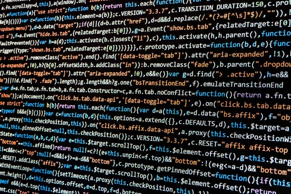 Tela de computador preenchida por linhas de código JavaScript