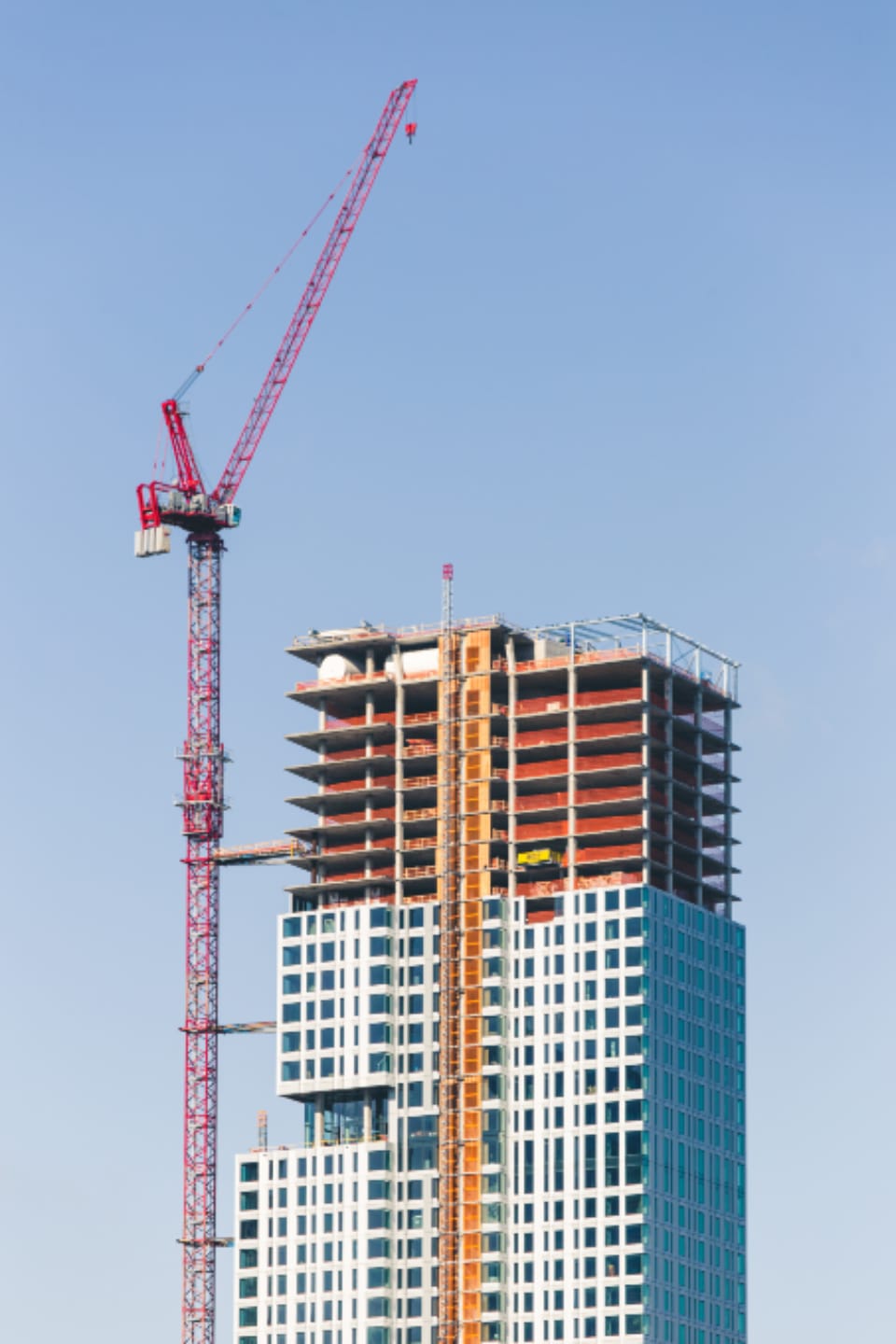 Guindaste vermelho ao lado de um edifício alto em construção